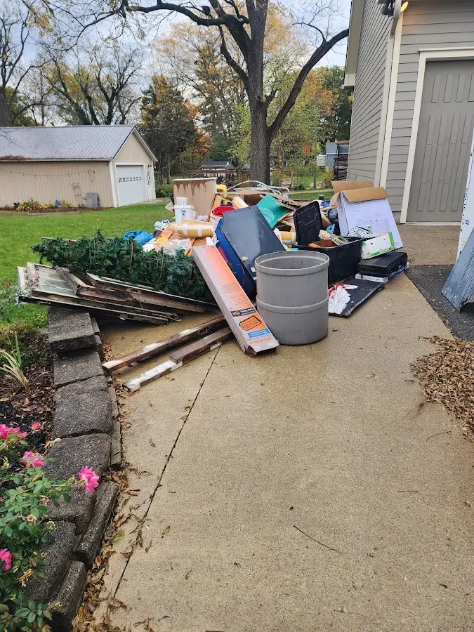 Dumpster being loaded with debris for Estate Cleanout Dumpster Rental in Pontiac
